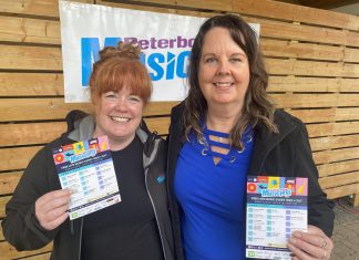 Peterborough Musicfest board chair Tracy Condon (left) and general manager Tracey Randall displaying the free-admission outdoor music festival's lineup for its 37th season during an announcement on May 14, 2024 at Millennium Park. (Photo: Paul Rellinger / kawarthaNOW)