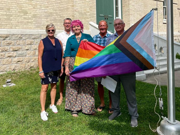 Not all communities in the Kawarthas region are hosting their Pride celebrations during Pride Month in June. Peterborough's Pride Week takes place from September 20 to 29, 2024, and Kawartha Lakes' Pride Week takes place from July 8 to 14, 2024. Pictured is Kawartha Lakes Mayor Doug Elmslie (right) participating in the 2023 flag raising to kick off the Kawartha Lakes Pride Week.  (Photo: Kawartha Lakes Pride / Facebook) 