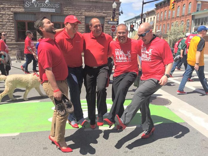 Scotiabank branch manager John D'Altoe (middle) and staff will don red T-shirts and red high-heels to represent Scotiabank at the "Walk A Mile In Their Shoes" fundraiser in support of YWCA Peterborough Haliburton on May 24, 2024. While many participants choose to wear red high heels to represent their support for women experiencing gender-based violence, the footwear is entirely optional, although wearing red shoes is encouraged. (Photo courtesy of Scotiabank)