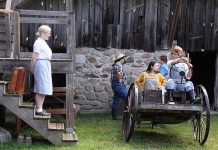 Jay (Rebecca Birrell, left) about to become a Farmerettes in a scene from 4th Line Theatre's "Onion Skins & Peach Fuzz: The Farmerettes" during a media day event on June 18, 2024 at the Winslow Farm in Millbrook. The world premiere of Alison Lawrence's play based on the 2019 book by Shirleyan English and Bonnie Sitter, which tells the little-known story of the young women who kept Canadian farms going during the Second World War, runs from July 1 to 20. (Photo: Jeannine Taylor / kawarthaNOW)