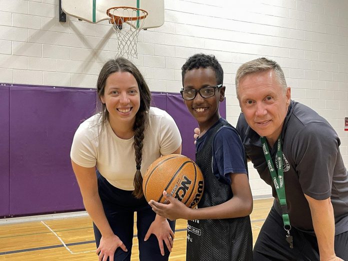 Five Counties Children's Centre recreation therapist Caitlin Ivany and Peterborough Youth Basketball Association diversity coordinator Joseph Hays pose with one of this spring's JumpBall participants. (Photo courtesy of Five Counties Children's Centre)