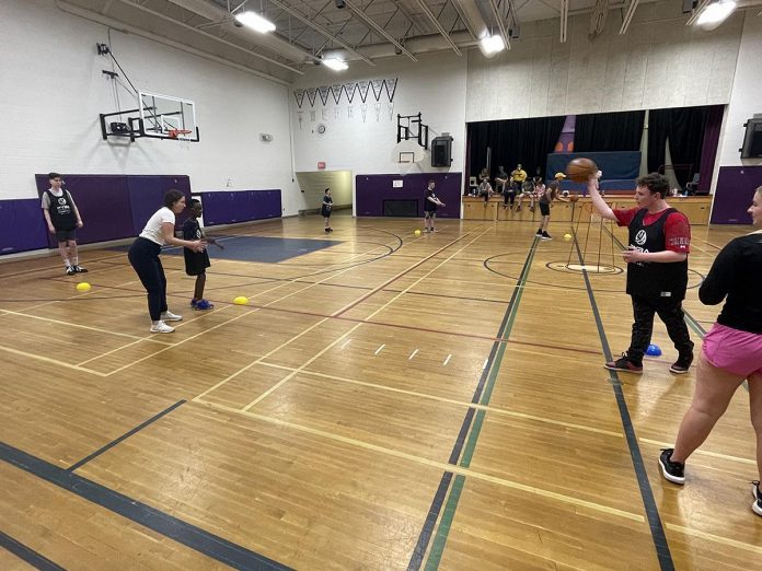 The JumpBall program introduces kids with exceptionalities to basketball, helping them enjoy a sport they might not otherwise try. Here, participants take part in a group skill-building sessions in which they practise bounce passes to each other. (Photo courtesy of Five Counties Children's Centre)