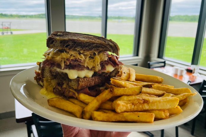 One of the most popular sandwiches served at The Good Baker YPQ is the classic Reuben, made with corn beef, Swiss cheese, sauerkraut, and housemade Thousand Island dressing and served with fries. Brad Katz, who first opened The Good Baker at the YMCA building in downtown Peterborough, is hosting a grand opening celebration of his second location at the Peterborough Airport on June 15 and 16, 2024. With mini cupcakes and discounts available, diners can enter a ballot to win passes for local businesses and a free one-hour sightseeing flight. (Photo courtesy of The Good Baker YPQ)