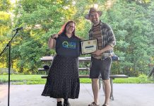 Dylan Radcliffe accepts a Shifting Gears workplace award on behalf of Engage Engineering from Peterborough GreenUP's Ashley Burnie during a 20th anniversary celebration at Nicholls Oval Park on May 31, 2024, which saw six businesses or organizations receive the awards. (Photo courtesy of GreenUP)