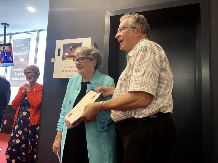 Peterborough mayor Jeff Leal presents Beth McMaster, founding chair of Showplace Performance Centre, with a certificate from the city during a celebration of McMaster at the downtown performing arts venue on June 11, 2024. (Photo: Paul Rellinger / kawarthaNOW)