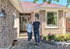 Norma and Michael Doran stand in front of their now fully electric Peterborough west-end home after having successfully completed a deep energy retrofit that allowed them to reduce their residential greenhouse gas emissions by over 86 per cent. (Photo: Clara Blakelock / GreenUP)