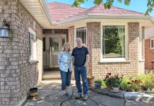 Norma and Michael Doran stand in front of their now fully electric Peterborough west-end home after having successfully completed a deep energy retrofit that allowed them to reduce their residential greenhouse gas emissions by over 86 per cent. (Photo: Clara Blakelock / GreenUP)