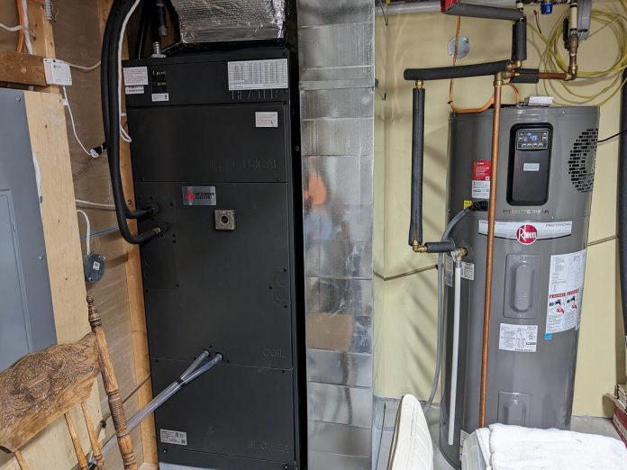 The mechanical room in the Dorans' basement contains an air handler for the heat pump and a heat pump hot water heater. The Dorans no longer use any natural gas appliances. (Photo: Clara Blakelock / GreenUP)