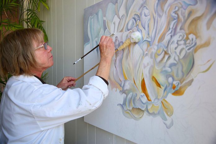 Mary McLoughlin working on a painting from her studio at 129 Hunter Street West in downtown Peterborough. McLoughlin has worked as an oil painter for 20 years and her studio will be Tour Stop 11 during the 40th anniversary Kawartha Autumn Studio Tour, taking place September 28 and 29, 2024. (Photo courtesy of the Art Gallery of Peterborough)