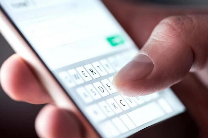 A man texting on a mobile phone. (Stock photo)