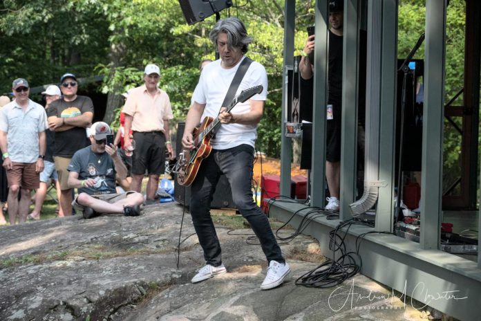 54-40 lead singer and guitarist Neil Osborne steps off the "stage" at Bruce and Susan Hodges' cottage on Stoney Lake during the fifth annual Wanakuen Concert on July 13, 2024, which also featured Newcastle's Chalk Circle. The private concert raised almost $40,000 for Ronald McDonald House Charities (RMHC) Toronto, which provides support to families dealing with the realities of caring for a child who is seriously ill. (Photo: Andrew Clowater)