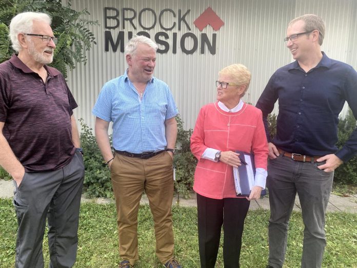 From left to right in front of Brock Mission on Murray Street in Peterborough: Brock Mission board member and project lead Alan Wilson, Brock Mission executive director Bill McNabb, Brock Mission clinic founder Major (Retired) Lee-Anne Quinn, and Peterborough and Kawarthas Chamber of Commerce vice-president Joel Wiebe. (Photo: Paul Rellinger / kawarthaNOW)