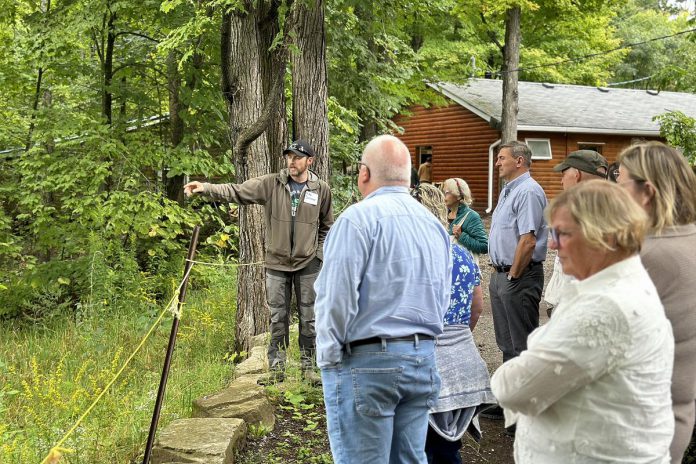 Camp Kawartha property manager Mike Schmor explains how the non-profit educational organization's new environmentally friendly septic system works during an informational tour at the organization's Douro-Dummer location on September 10, 2024, attended by Peterborough-Kawartha MPP Dave Smith and representatives from donor organizations including Ontario Trillium Foundation and Williams Wilson Sherport Foundation. The septic system uses the patented Waterloo Biofilter system originally developed at the University of Waterloo. (Photo courtesy of Camp Kawartha)