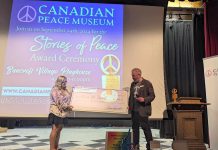 Angela Reid, office administrator of Coe Hill School, accepts a cheque for $500 from Chris Houston, founder of the Canadian Peace Museum, during the Stories of Peace Award ceremony on September 24, 2024 at Bancroft Village Playhouse. The school, which won the second annual ward for its video submission, also received a trophy and congratulatory scrolls from the federal and provincial governments. (Photo: Dave Raymond)