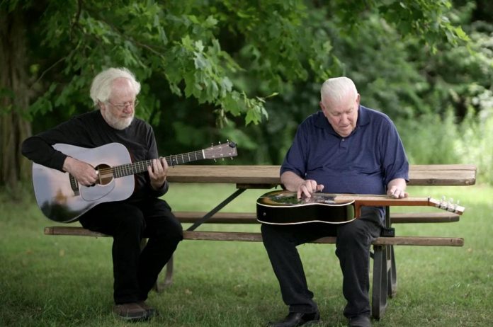 Peterborough music scholar and musician Al Kirby (right) performing with Irish traditional singer and song collector Daithí Sproule, host of the "Woods Music" documentary about  the history of Irish songs in Canada, currently streaming on CBC Gem. (kawarthaNOW screenshot)