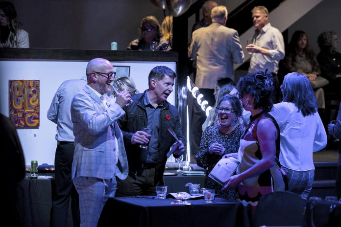 Bidders enjoy drinks and hors d'oevres at the 2023 It's All About ART fundraising auction held by the Art Gallery of Peterborough at The Venue in downtown Peterborough. In celebration of the art gallery's 20th anniversary, this year's fundraiser will have a "groovy" 1970s theme, with music from the decade, disco balls decorating The Venue, and guests strutting their best bell-bottoms. (Photo: Zach Ward)