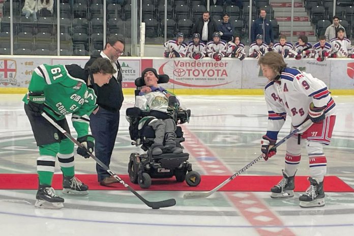 Five Counties Children's Centre CEO Scott Pepin and alumnus Nick Scarr, a huge Cobourg Cougars fan, during the puck drop before the inaugural Cougars for Kids game in 2023. Five Counties is teaming up with the Cougars again for the second annual Cougars for Kids game at the Cobourg Community Centre on November 16, 2024. Funds raised from the game will support treatment services for children and youth with special needs in Northumberland County. (Photo: Five Counties Children's Centre)