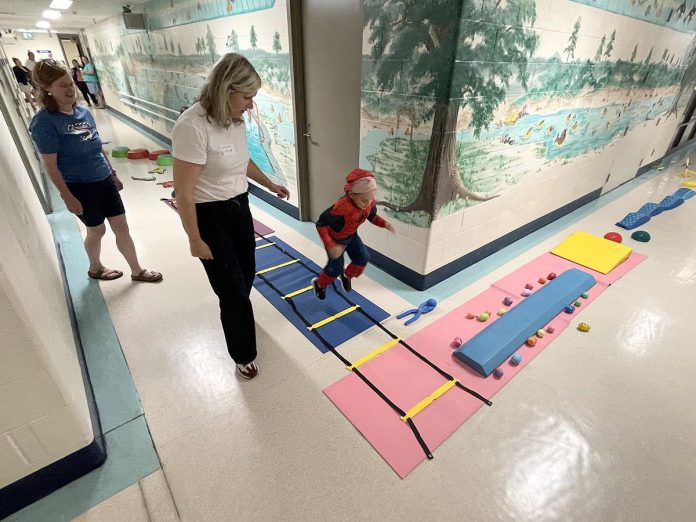 From left, Five Counties clinicians Katie and Ange watch one of the Heel-Toe Express Group participants wind his way through an obstacle course. The physiotherapy program helped children who continue to walk on their toes learn exercises and stretches with the aim of helping them find their proper stride. Fun and physio were combined to make the session engaging and interesting for the kids. (Photo courtesy of Five Counties Children's Centre)