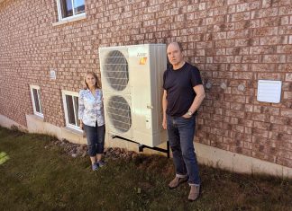 Peterborough residents Michael and Norma Doran pose with their heat pump, which they installed in 2023. The Dorans worked with GreenUP's home energy team to evaluate their home's efficiency, and were able to take advantage of an incentive program to upgrade their home. You can learn more about heat pumps and other energy-saving solutions, incentive programs, and more at the Home Energy Expo on October 19, 2024 at the McDonnel St. Activity Centre in Peterborough. (Photo: Clara Blakelock / GreenUP)