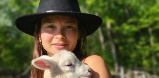 Beatrice Chan, the new program coordinator of the Net Zero Farms program, with one of her lambs from her farm in Selwyn Township where she farms sheep, cut flowers, meat chickens, and runs a flock of layers as well. She is looking forward to working with other local farmers in her new role as coordinator. (Photo: Bea Chan)