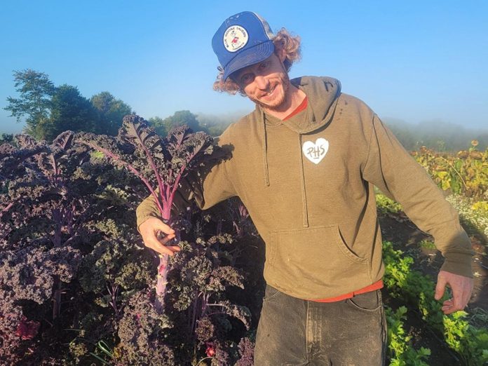 Josh Blank, veggie farmer at Carrot Top Organics, was an active member of the first cohort of farmers through the Net Zero Farms pilot project, and one of members who received an Greenhouse Gas Inventory Report through their participation. (Photo: Carrot Top Organics)