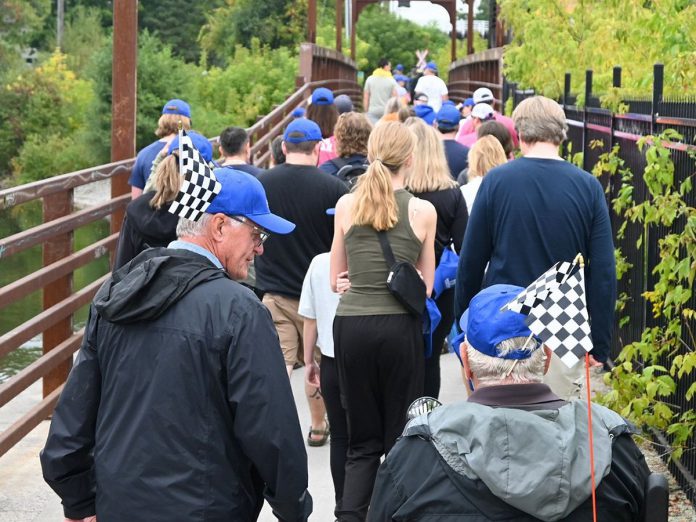 Participants in the annual Hike for Hospice fundraiser for Hospice Peterborough cross the bridge from Millennium Park on their way to Roger's Cove in East City on September 22, 2024. (Photo: Anne Leavens)