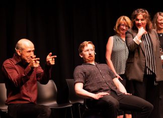 Kerry Griffin performs an unconventional kind of therapy on Mark Rostrup as Janet Van Der Graaff, Linda Kash, and Naomi Snieckus look on during klusterfork's "School's Out!" improv show at the Market Hall in July 2023. Griffin and Van Der Graaff are two of the improv professionals who will perform in klusterfork's "Impros vs. Joes" improv comedy show at the Gordon Best Theatre in downtown Peterborough on November 15, 2024, along with klusterfork's "Keep Me Up" improv workshop students. (Photo: Andy Carroll)