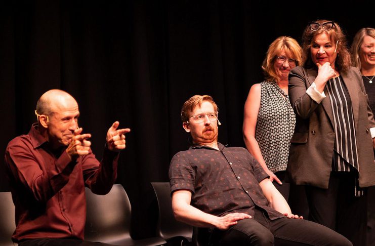 Kerry Griffin performs an unconventional kind of therapy on Mark Rostrup as Janet Van Der Graaff, Linda Kash, and Naomi Snieckus look on during klusterfork's "School's Out!" improv show at the Market Hall in July 2023. Griffin and Van Der Graaff are two of the improv professionals who will perform in klusterfork's "Impros vs. Joes" improv comedy show at the Gordon Best Theatre in downtown Peterborough on November 15, 2024, along with klusterfork's "Keep Me Up" improv workshop students. (Photo: Andy Carroll)