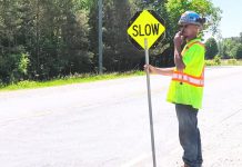 A road construction worker in Peterborough County. (kawarthaNOW screenshot of Peterborough County video)