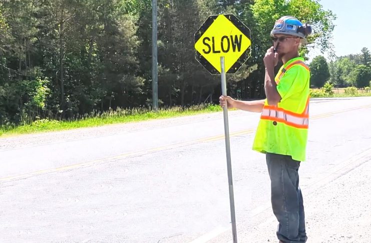 A road construction worker in Peterborough County. (kawarthaNOW screenshot of Peterborough County video)