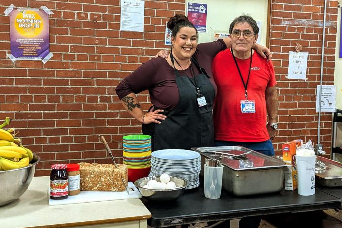 Kristal Jones-Craighead, a social worker with the Elizabeth Fry Society of Peterborough who is also coordinator of the morning drop-in program at Trinity Centre in Peterborough, with "coffee master" Wayne. Experiencing homelessness himself, Wayne volunteers at the program every weekday morning to make and serve coffee, set up tables, and do dishes. (Photo courtesy of Kristal Jones-Craighead)