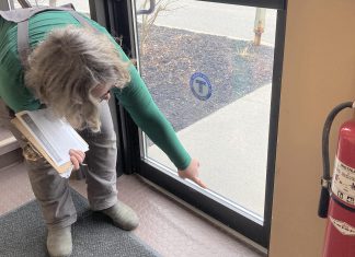 Addressing airtightness in your commercial building can be a low-cost place to start improving energy efficiency. Clara Blakelock, a registered energy advisor with GreenUP, points out a gap at the bottom of an exterior door. Adding a doorsweep to the door will mitigate energy loss. (Photo: Jackie Donaldson)