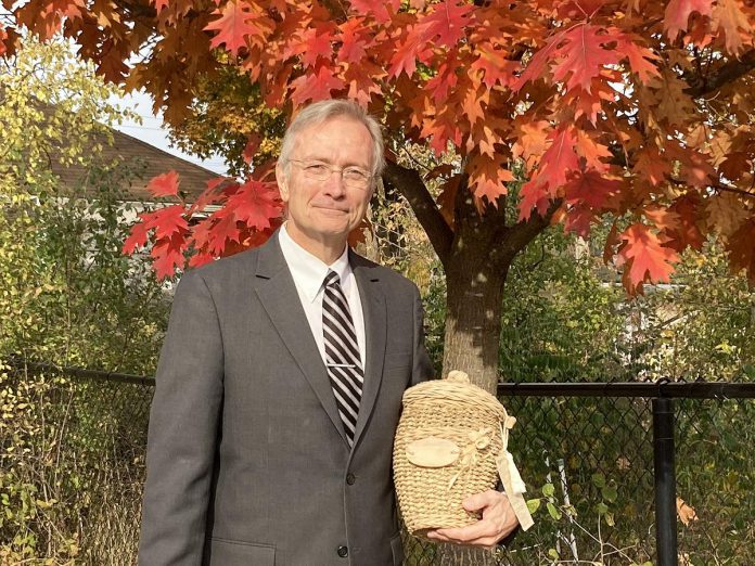 John Cunningham, president and managing director of Ashburnham Funeral Home, holds a biodegradable wicker urn. Other options available for those seeking eco-friendly end-of-life services include aquamation, basic wooden or cardboard caskets, and low-impact burials. (Photo: Jackie Donaldson)