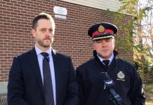 Detective sergeant Josh McGrath and deputy police chief Jamie Hartnett speak to the media on November 13, 2024 at the site of a shooting at 850 Fairbairn Street in Peterborough, where three male suspects fired multiple shots into the townhomes and into the air the previous night. No one was injured in the incident, which police believe is connected to the illicit drug trade. (kawarthaNOW screenshot of police video)