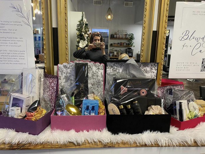 Brooke Roberts takes a photo of the four gift baskets at Peterborough's Hair by Fusion that are part of a fundraiser for pediatric cancer care at Peterborough Regional Health Centre (PRHC) in honour of her daughter Sofie, who died on on May 17, 2024 after a courageous nine-month battle with brain cancer. On December 14, 2024, during the celebration that will mark the end of the fundraiser two days before what would have been Sofie's 10th birthday, there will be a draw for four gift baskets. Every $20 donated will earn a ballot in the draw. Proceeds from blow dries and select product sales at Hair by Fusion before December 14 will also be included in the fundraiser. (Photo: Brooke Roberts)