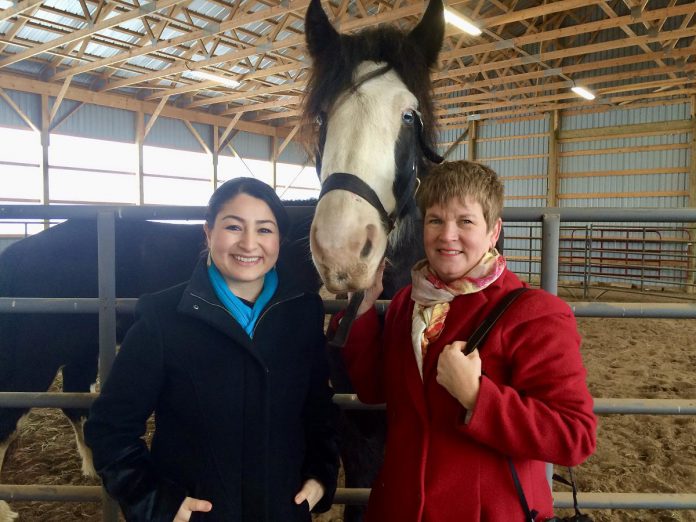 Former Peterborough-Kawartha MPP and Minister for Women and Gender Equality and Youth of Canada Maryam Monsef with The Mane Intent founder Jennifer Garland, RP and Blue the horse on the day of the funding announcement for the Building Internal Resilience Through Horses Research project between Kawartha Sexual Assault Centre, Trent University, and The Mane Intent. Over five years, the program supported female youth who experienced or witnessed violence in their homes or intimate partner violence by helping them build fundamental pillars of personal resilience. (Photo courtesy of The Mane Intent) 