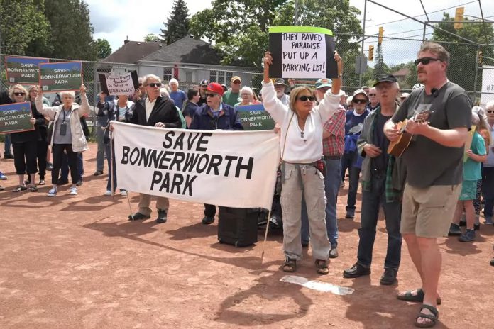 More than 250 people attended a "Save Bonnerworth Park" rally on May 18, 2024 at the park at McDonnel Street and Monaghan Road where the City of Peterborough approved a $4.1-million redevelopment project that includes 14 pickleball courts, an expanded skate park, a bike pump track, and a parking lot. (kawarthaNOW screenshot of Mark Wollard video)