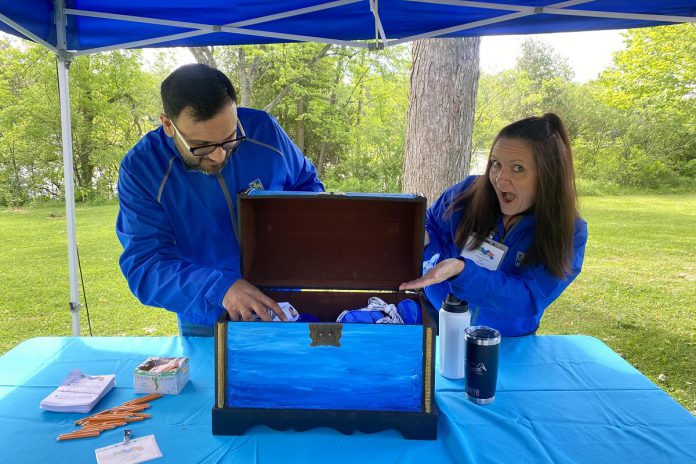 RBC staff members Sahil Jain and Christa Sandiland welcome students to one of the activity centres at the 2024 Peterborough Children's Water Festival. RBC employees made a donation to support the festival, one of many local business and organizations that contributed to the day. (Photo: Natalie Stephenson / GreenUP)