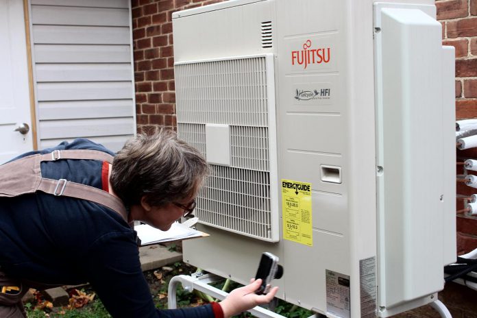 Clara Blakelock, Program Manager of the Home Energy Program at GreenUP, analyzes a cold-climate air-source heat pump. A shift in funding priorities by the federal government has also affected GreenUP's home energy program to reduce local energy usage and greenhouse gas emissions. The Canada Greener Homes grant, which provided homeowners with up to $5,000 toward energy efficiency upgrades, unexpectedly ended earlier this year. (Photo courtesy of GreenUP)