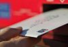 A hand depositing a letter into a mailbox. (Photo: Canada Post)