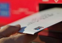 A hand depositing a letter into a mailbox. (Photo: Canada Post)