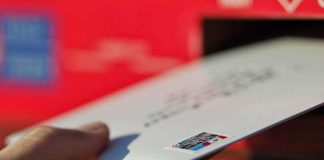 A hand depositing a letter into a mailbox. (Photo: Canada Post)