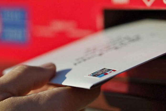 A hand depositing a letter into a mailbox. (Photo: Canada Post)