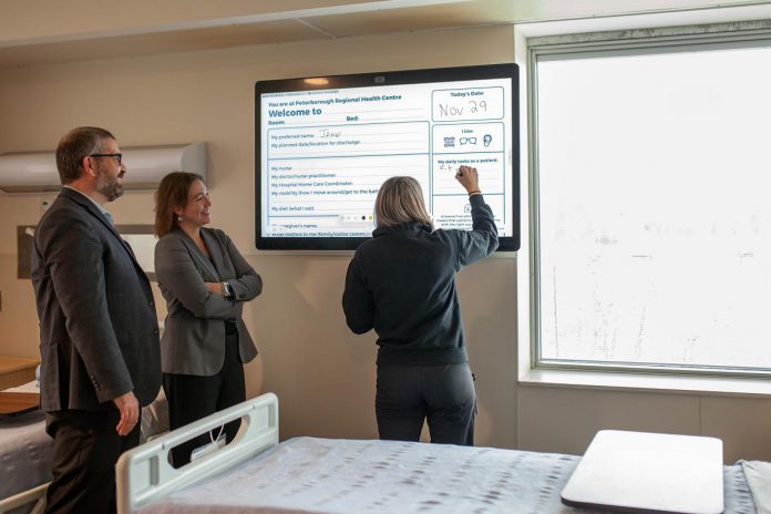 Peterborough Regional Health Centre Vice President and Chief Nursing Executive Noel Bennett (left) and President and CEO Dr. Lynn Mikula watch as Occupational Therapist Beth Morgan uses the new, innovative technology within the recently opened Reactivation Care Centre at the regional hospital. The installation of digital communication boards from Cisco Systems enhances communications and ensure patients are empowered through involvement in their own health care. (Photo courtesy of PRHC)