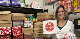 Lindsay Community Food Market coordinator Ashley Anderson with some of the 50 gift-filled shoeboxes distributed to Kawartha Lakes Food Source by The Shoebox Project's Kawartha Lakes chapter for women in the Kawarthas region who are experiencing poverty or homelessness. Thanks to gift donors and sponsors, the Kawartha Lakes chapter of The Shoebox Project for Women collected and delivered 210 gift-filled shoeboxes for the 2024 holiday season. (Photo courtesy of The Shoebox Project Kawartha Lakes)