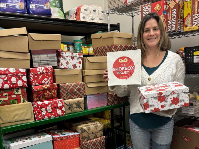 Lindsay Community Food Market coordinator Ashley Anderson with some of the 50 gift-filled shoeboxes distributed to Kawartha Lakes Food Source by The Shoebox Project's Kawartha Lakes chapter for women in the Kawarthas region who are experiencing poverty or homelessness. Thanks to gift donors and sponsors, the Kawartha Lakes chapter of The Shoebox Project for Women collected and delivered 210 gift-filled shoeboxes for the 2024 holiday season. (Photo courtesy of The Shoebox Project Kawartha Lakes)