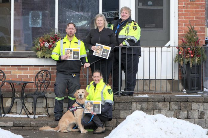 Through sales of the 2025 Paramedic Therapy Dog Calendar fundraiser featuring the Northumberland Paramedics therapy dog Ivy Joules (front), Northumberland Paramedics raised over $1,000 to deliver over 50 holiday meals to seniors and community members in need this winter. Pictured from left to right are Northumberland paramedic Joe Glass, Ketch's Korner owner Melissa Dale, Northumberland Paramedics Chief Susan Brown, and (with Ivy Joules) Northumberland Paramedics superintendent of quality improvement education Giselle Lech. (Photo: Northumberland County)