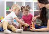 Two young children and an early childhood educator. (Stock photo)