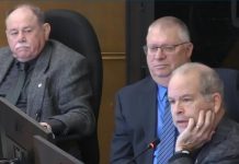 At Peterborough city council's general committee meeting on January 6, 2025, councillor Kevin Duguay (right) asks a question of city staff while councillors Keith Riel and Gary Baldwin look on during a discussion of a staff report recommending the city expand the modular bridge housing community at Wolfe Street by up to 16 cabins, if the city is successful in its application for $1.3 million in funding from two new provincial programs. The councillors were three of the six who voted in favour of the staff report, with five voting against. (kawarthaNOW screenshot of City of Peterborough video)