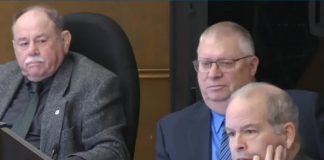 At Peterborough city council's general committee meeting on January 6, 2025, councillor Kevin Duguay (right) asks a question of city staff while councillors Keith Riel and Gary Baldwin look on during a discussion of a staff report recommending the city expand the modular bridge housing community at Wolfe Street by up to 16 cabins, if the city is successful in its application for $1.3 million in funding from two new provincial programs. The councillors were three of the six who voted in favour of the staff report, with five voting against. (kawarthaNOW screenshot of City of Peterborough video)